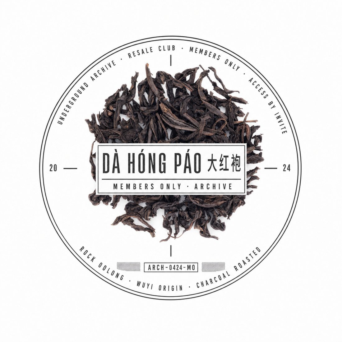 Squares of pressed ripe pu-erh inside a tall engraved silver oval on black, with curved rim lettering and a condensed name on a ribbon