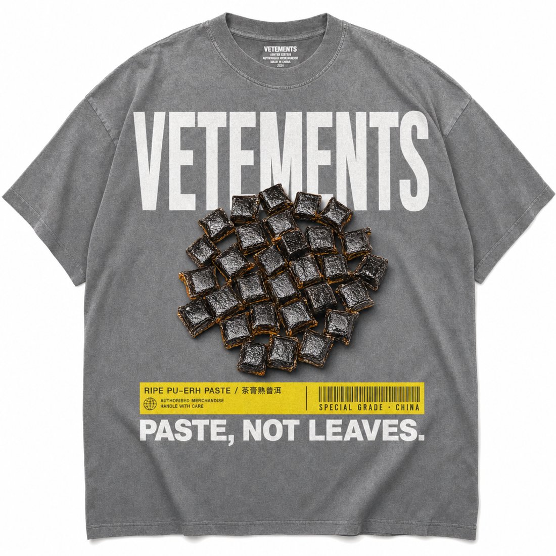 Washed grey oversized t-shirt printed with huge white capitals, a circle of pressed pu-erh squares and a yellow caption bar with a barcode